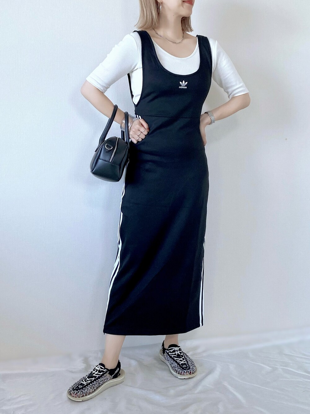 ブラック系のスカート、ホワイト系のTシャツ/カットソー、ブラック系のバッグを着用したレディースの春コーディネートの4枚目の写真