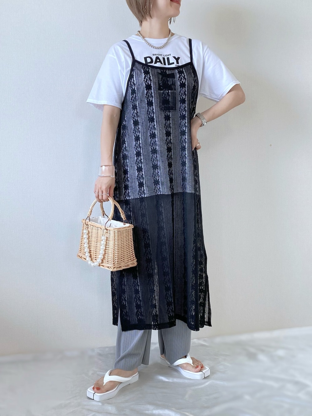 ブラック系のワンピース/ドレス、ベージュ系のかごバッグ、ホワイト系のTシャツ/カットソーを着用したレディースの夏コーディネートの2枚目の写真