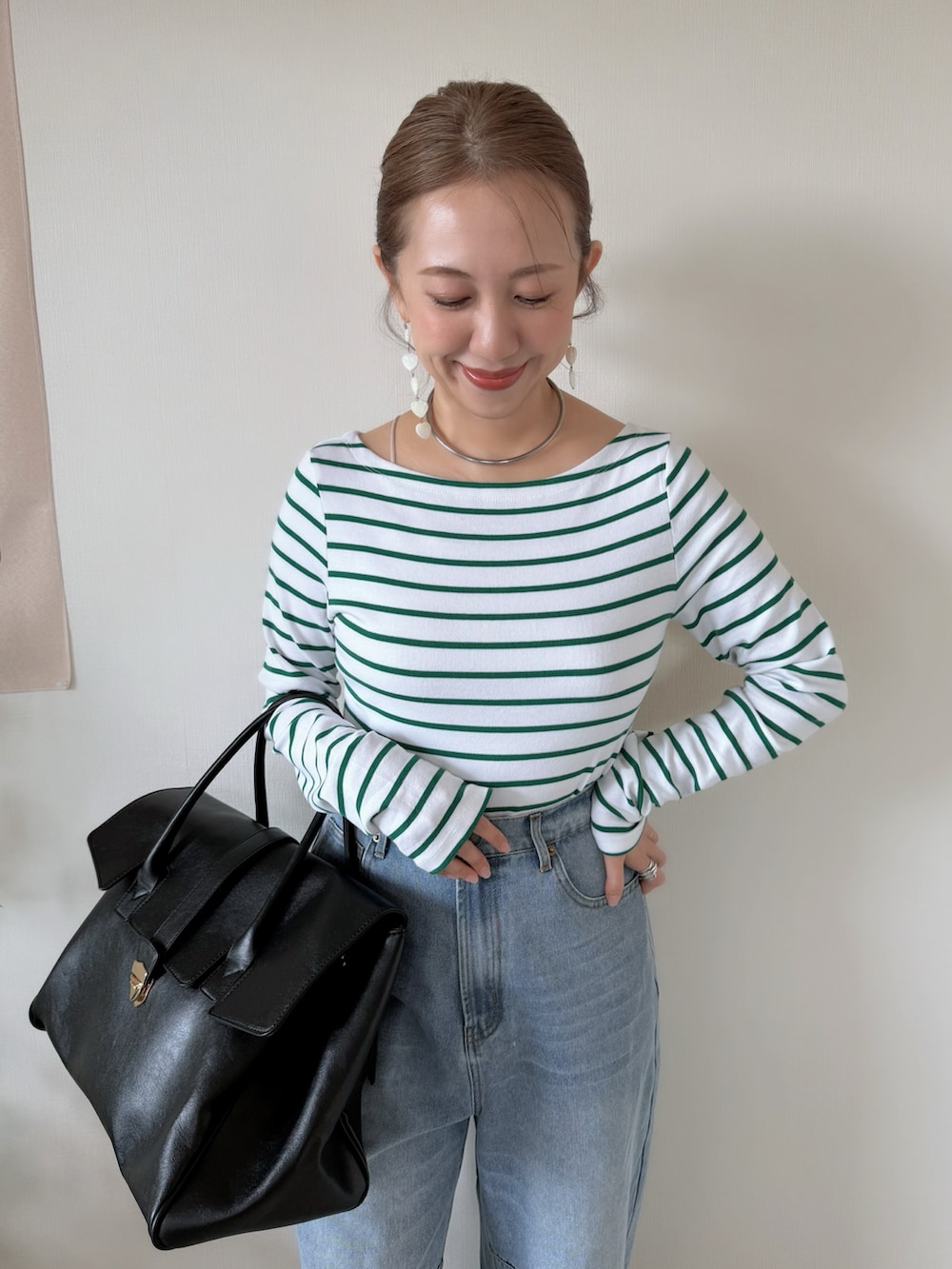 レッド系のバレエシューズ、ブラック系のボストンバッグ、グリーン系のTシャツ/カットソーを着用したレディースの春コーディネートの4枚目の写真