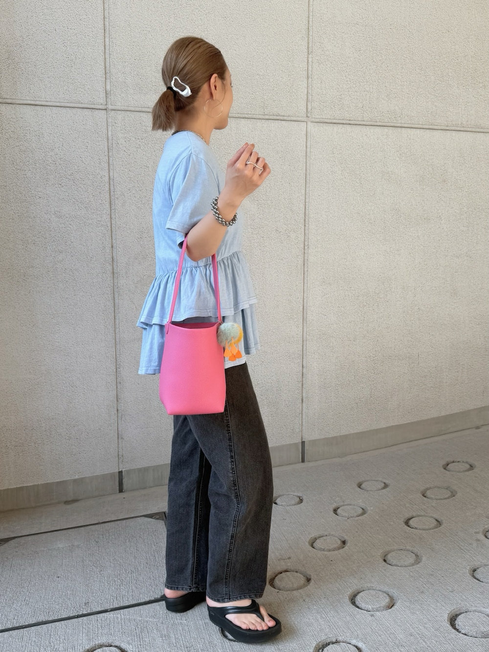 ブルー系のTシャツ/カットソー、ブラック系のデニムパンツ、ピンク系のショルダーバッグを着用したレディースの夏コーディネートの2枚目の写真