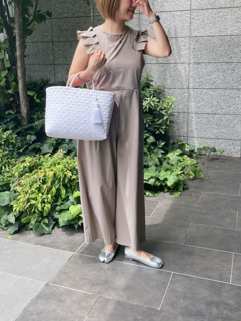 シルバー系のバレエシューズ、ベージュ系のラッシュガードを着用したレディースの夏コーディネートの2枚目の写真