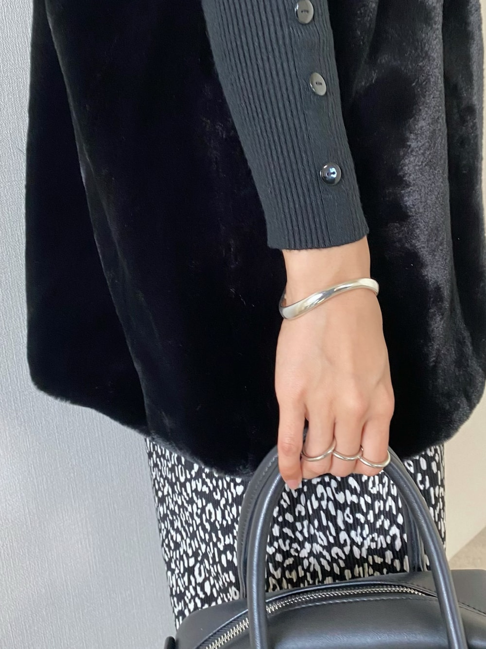 ブラック系のその他アウター、ブラック系のニット/セーター、ブラック系のバッグを着用したレディースの秋コーディネートの4枚目の写真