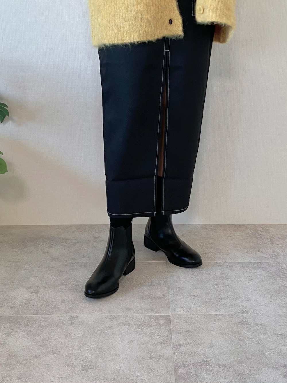 ブラック系のワンピース、ブラック系のブーツ、ブラック系のバッグを着用したレディースの冬コーディネートの5枚目の写真