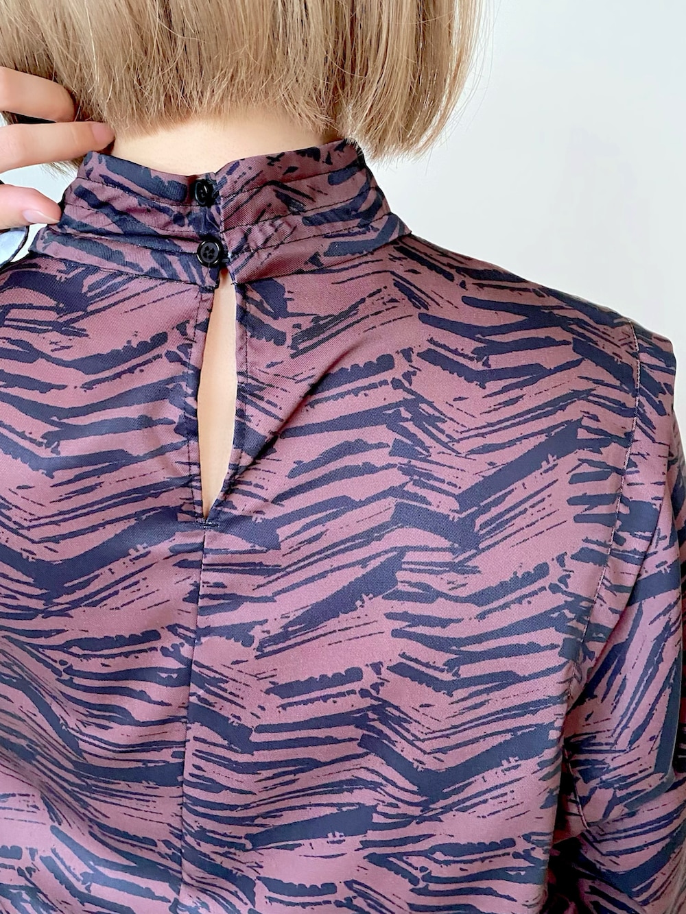 ブラウン系のワンピース、ブラック系のショルダーバッグ、ホワイト系のベストを着用したレディースの秋コーディネートの4枚目の写真