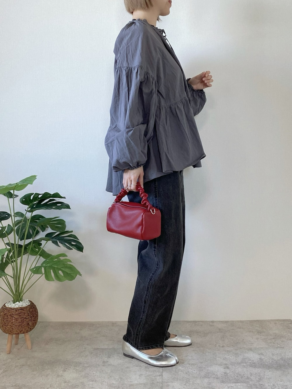 グレー系のシャツ/ブラウス、ブラック系のデニムパンツ、レッド系のボストンバッグを着用したレディースの春コーディネートの3枚目の写真