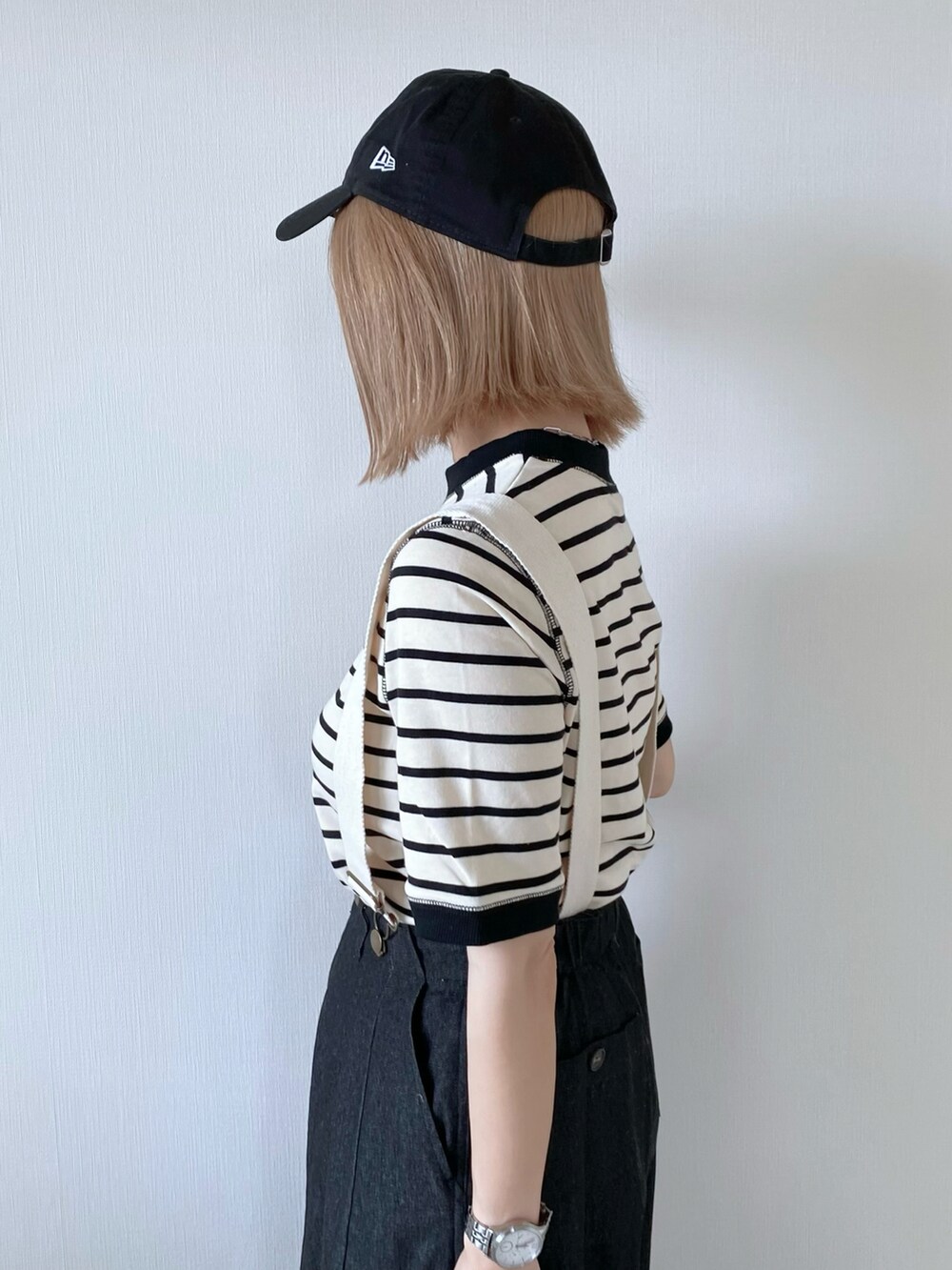 ブラック系のデニムパンツ、ブラック系のバッグ、ベージュ系のサンダルを着用したレディースの春コーディネートの4枚目の写真