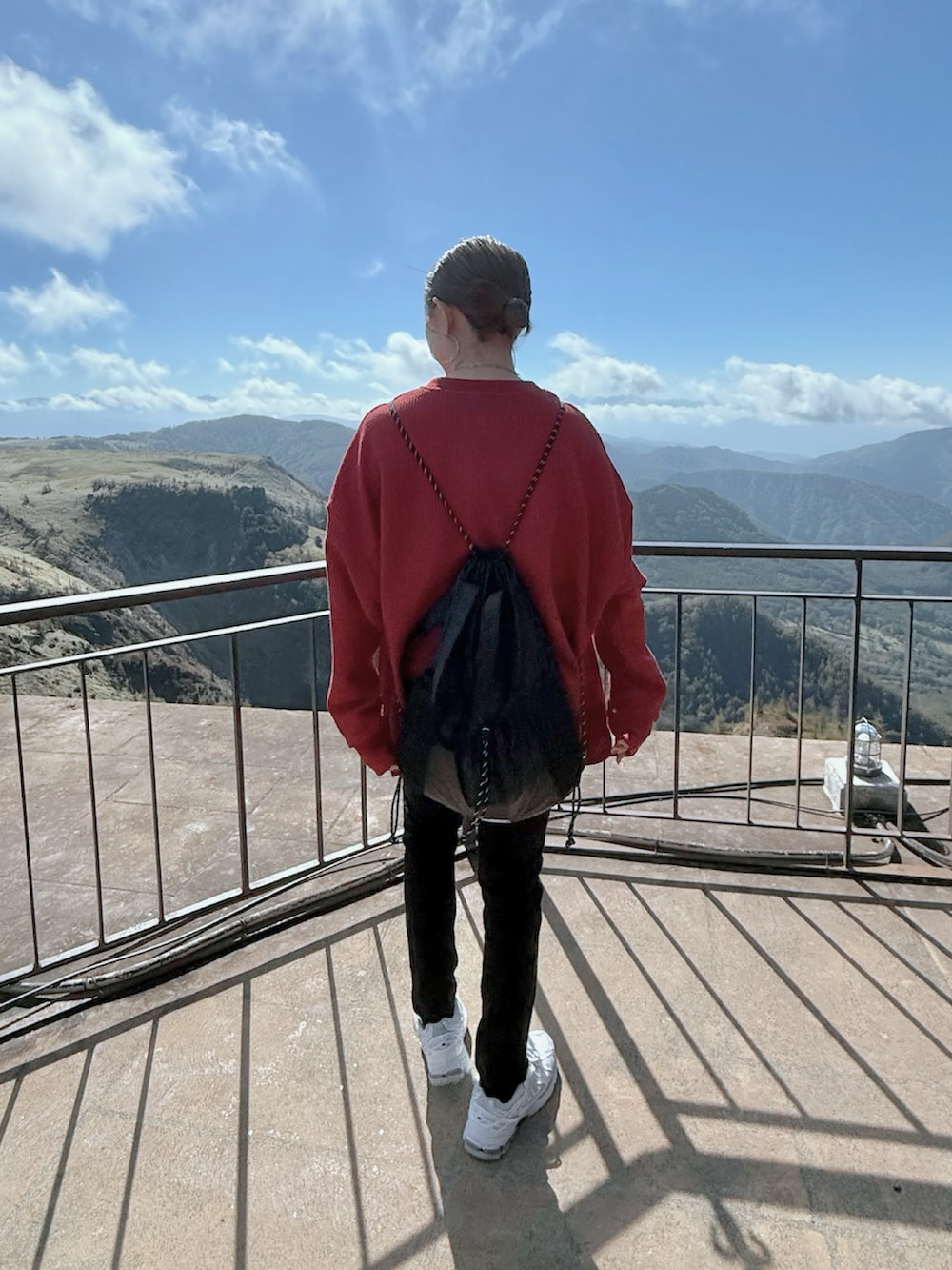 ホワイト系のスニーカー、レッド系のTシャツ/カットソー、ブラック系のバックパック/リュックを着用したレディースの秋コーディネートの3枚目の写真