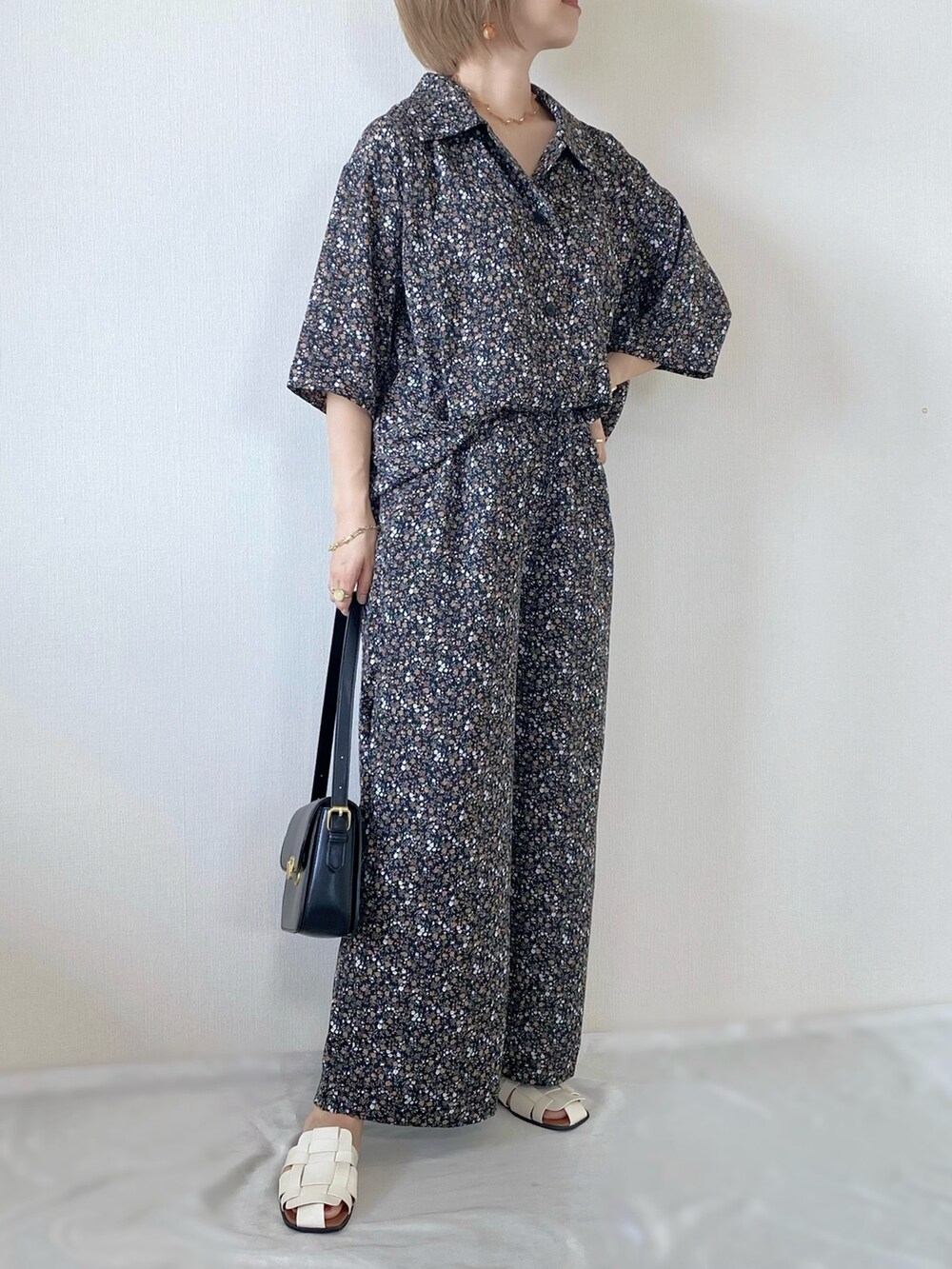 ブラック系のショルダーバッグ、ホワイト系のサンダル、ブラック系のシャツ/ブラウスを着用したレディースの夏コーディネートの4枚目の写真