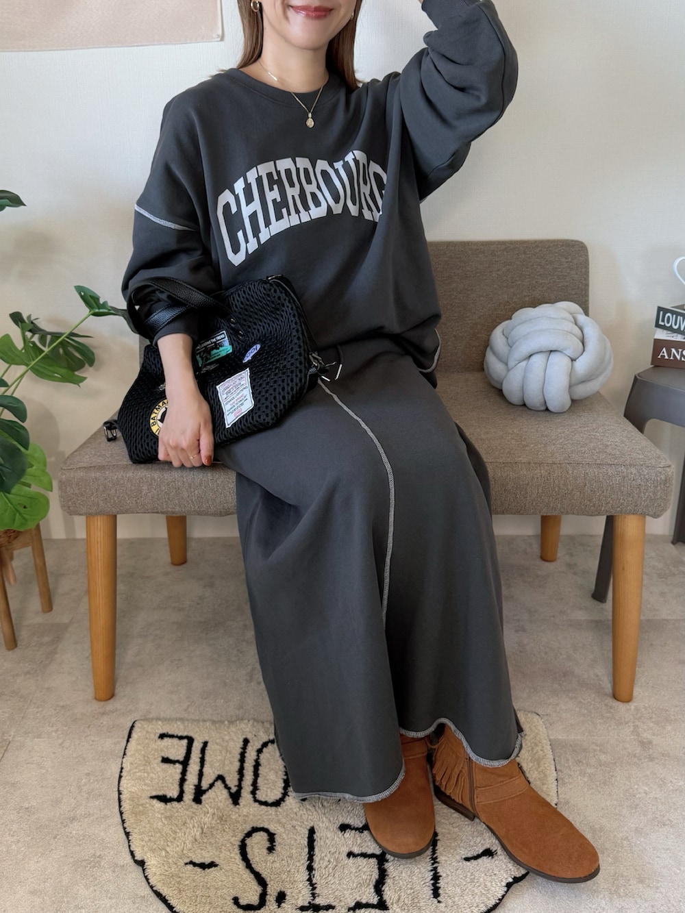 グレー系のスウェット、グレー系のスカート、ブラック系のボストンバッグを着用したレディースの冬コーディネートの2枚目の写真