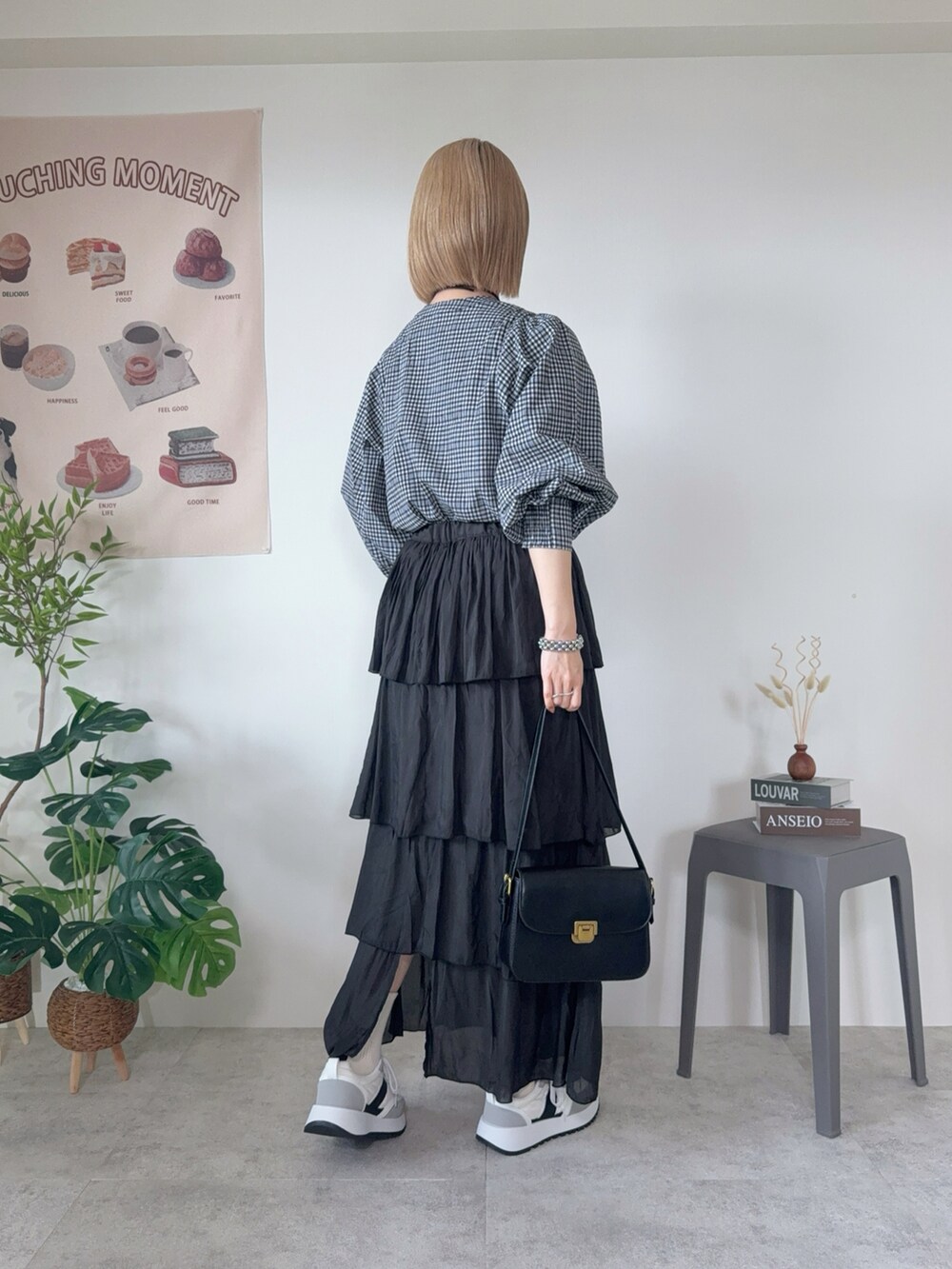 グレー系のスニーカー、ブラック系のスカート、ブラック系のシャツ/ブラウスを着用したレディースの春コーディネートの2枚目の写真