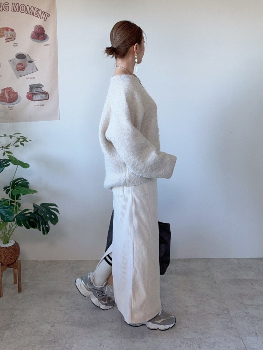 ベージュ系のニット/セーター、ベージュ系のスカート、グレー系のトートバッグを着用したレディースの冬コーディネートの2枚目の写真