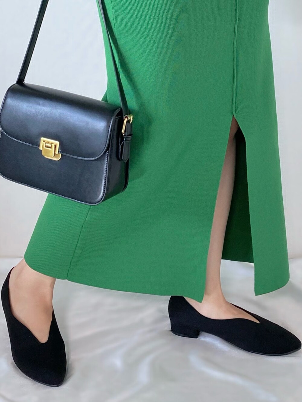 グリーン系のスカート、グリーン系のニット/セーター、ブラック系のショルダーバッグを着用したレディースの秋コーディネートの3枚目の写真