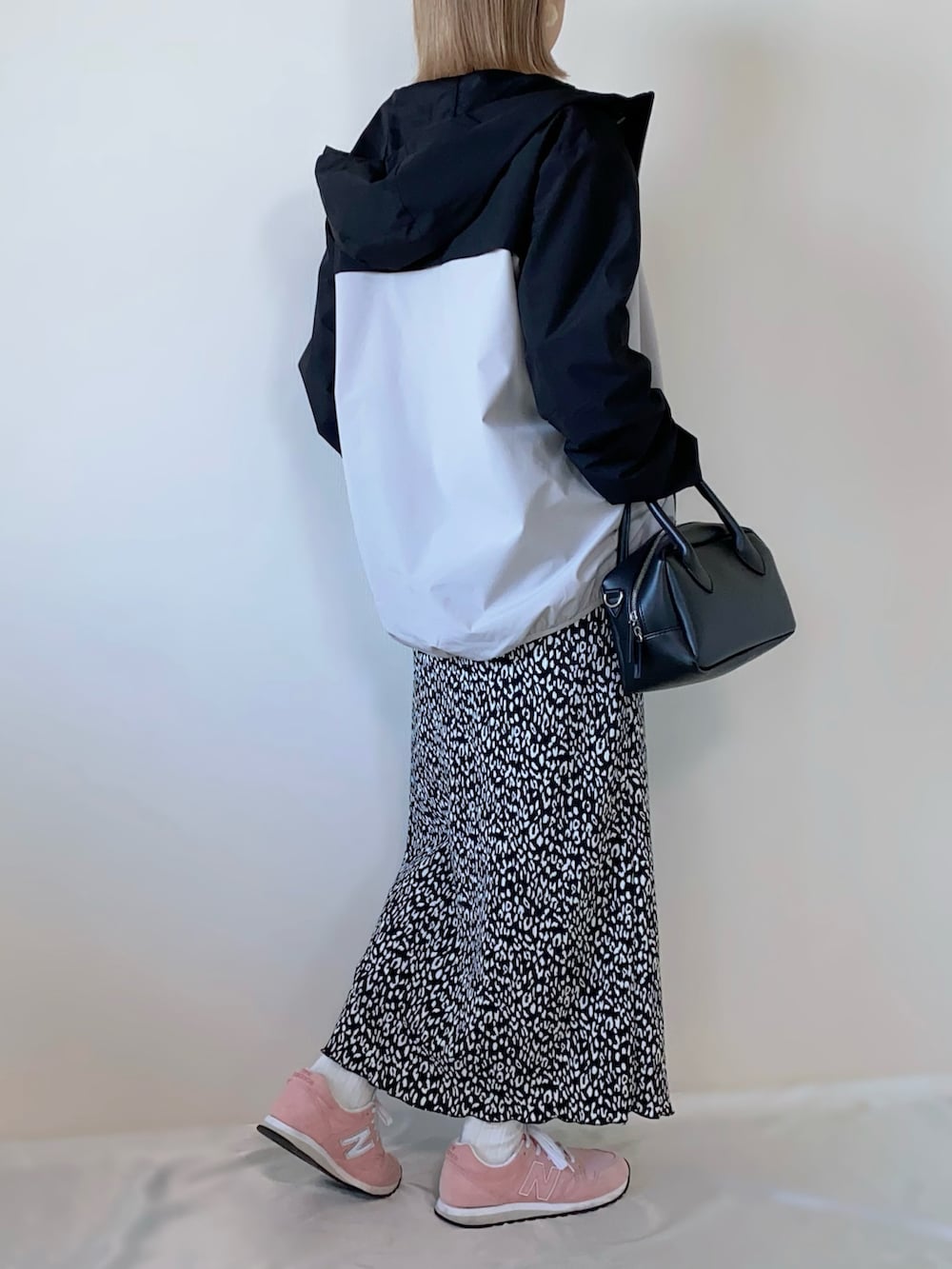 ブラック系のバッグ、ブラック系のスカート、ベージュ系のマウンテンパーカーを着用したレディースの春コーディネートの3枚目の写真