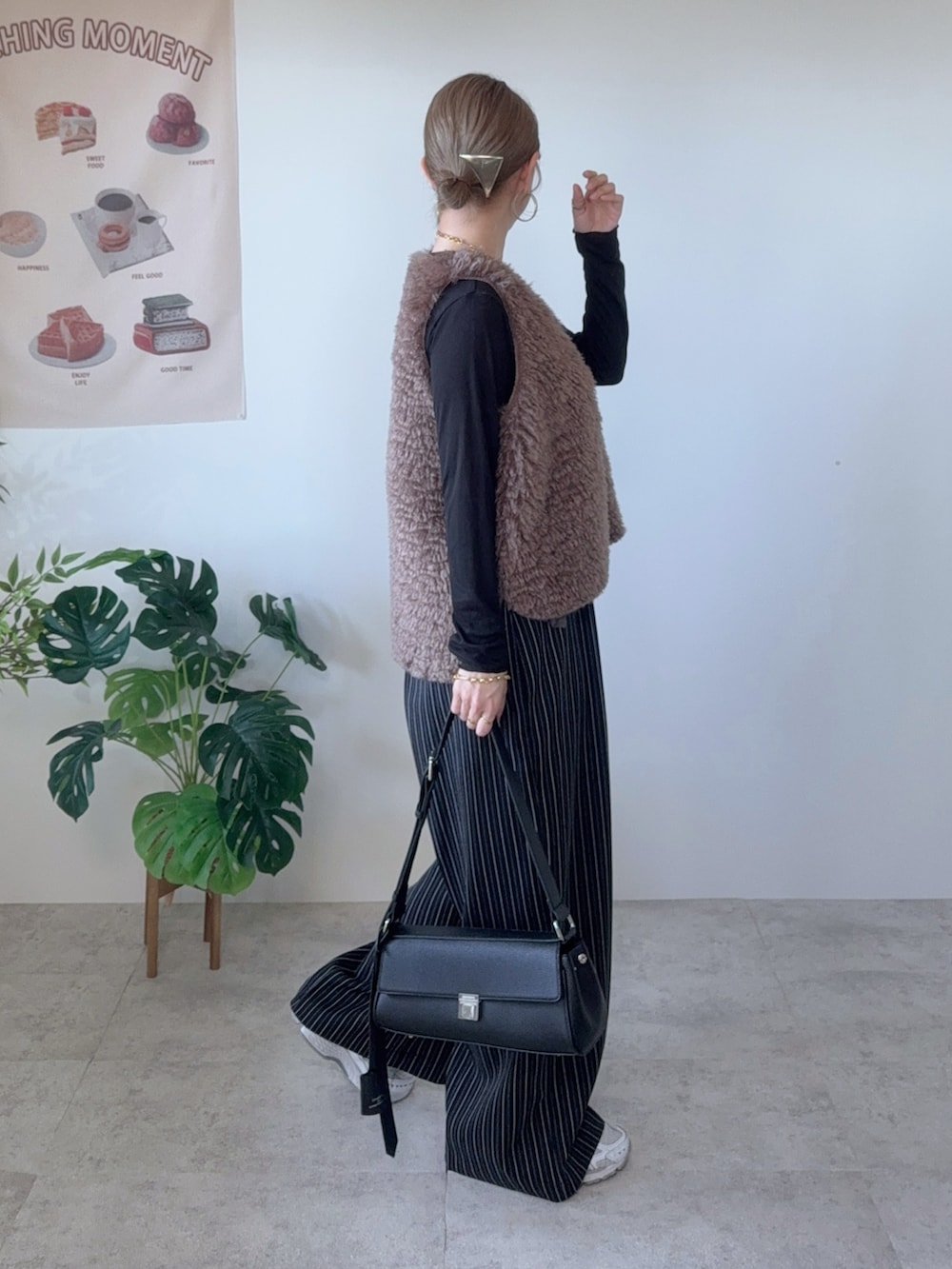 ブラック系のショルダーバッグ、ブラウン系のベスト、ブラック系のその他パンツを着用したレディースの秋コーディネートの3枚目の写真