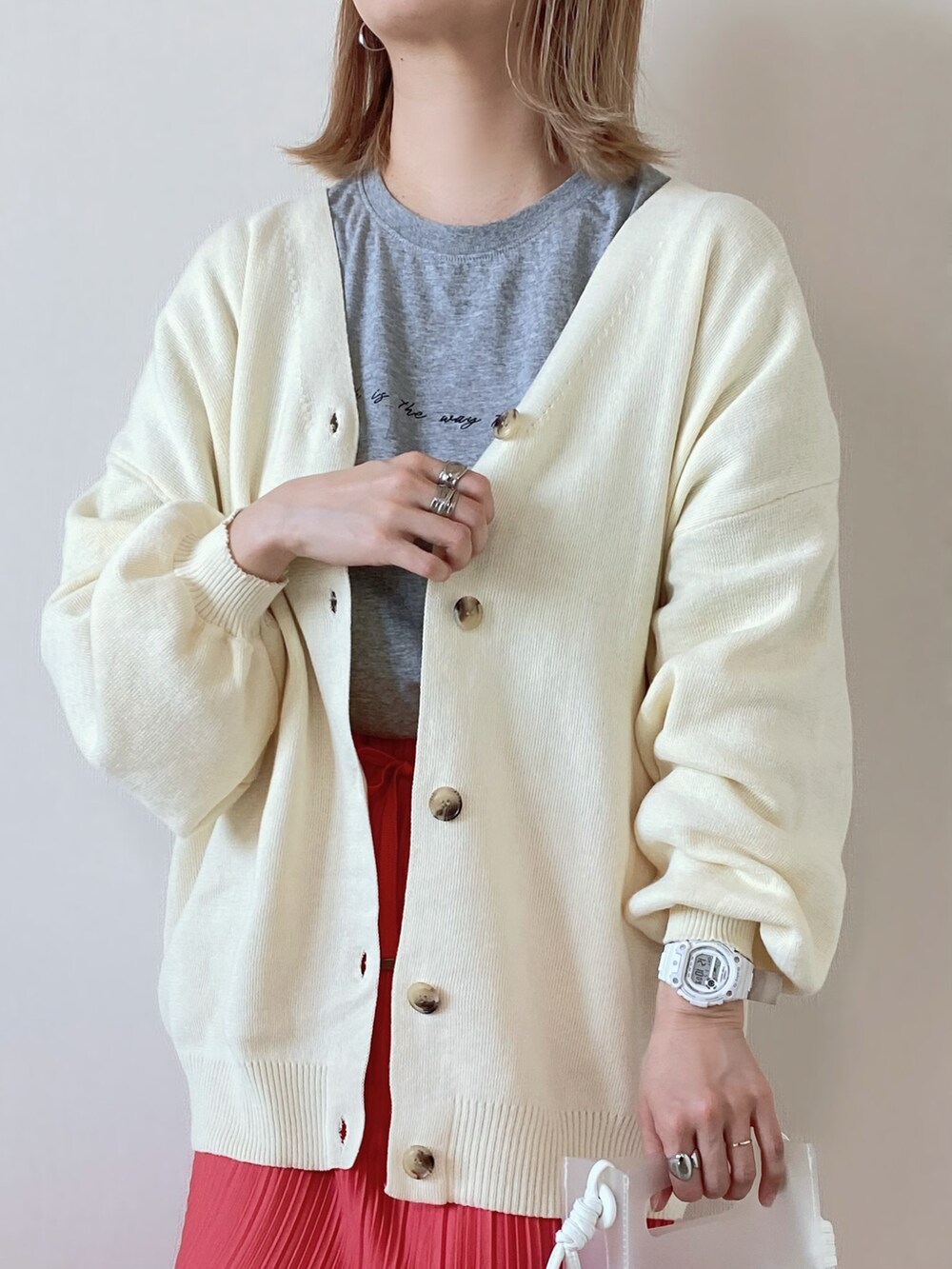 ホワイト系のカーディガン/ボレロ、ピンク系のスカート、ホワイト系のスニーカーを着用したレディースの春コーディネートの5枚目の写真