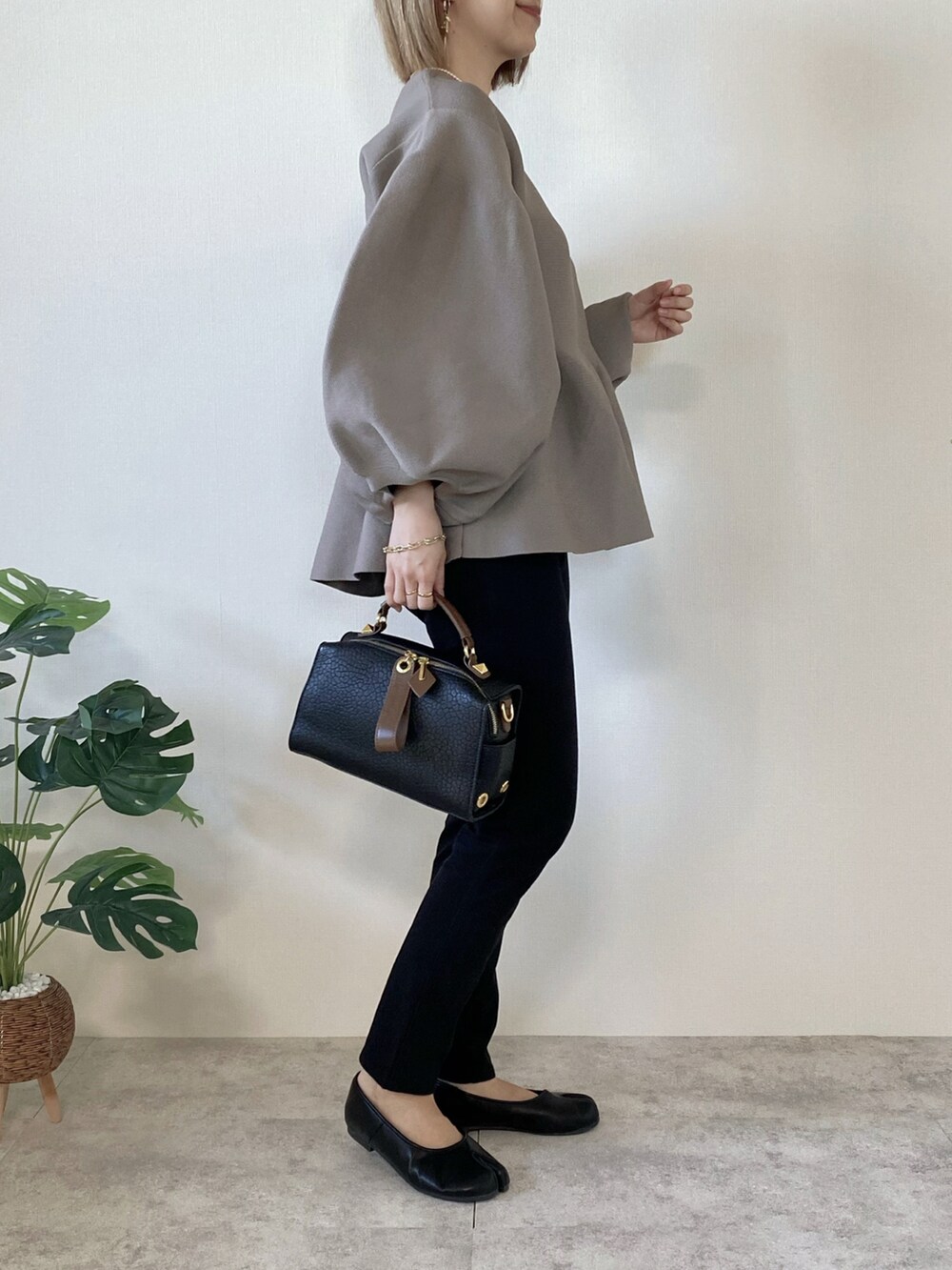 ブラウン系のTシャツ/カットソー、ブラック系のボストンバッグ、ブラック系のパンプスを着用したレディースの冬コーディネートの3枚目の写真