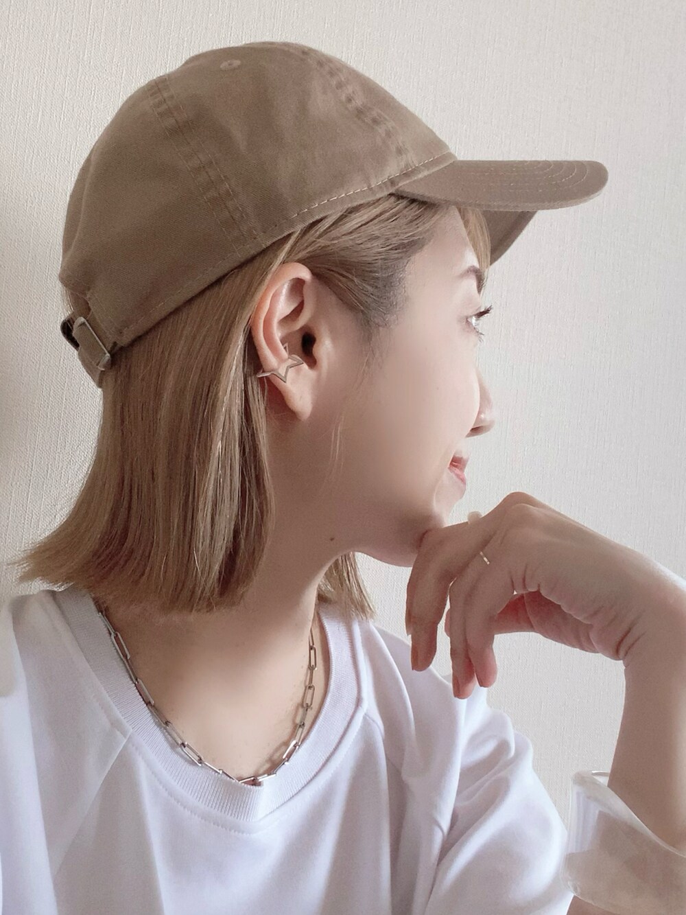 その他のイヤーカフ、イエロー系のキャップを着用したレディースの春コーディネートの2枚目の写真