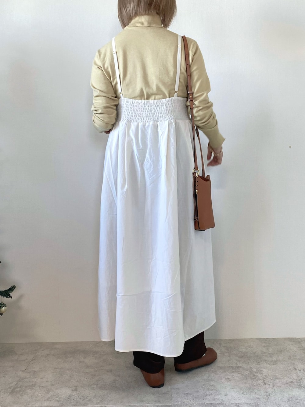 ホワイト系のワンピース、イエロー系のニット/セーター、ブラウン系のその他パンツを着用したレディースの冬コーディネートの4枚目の写真