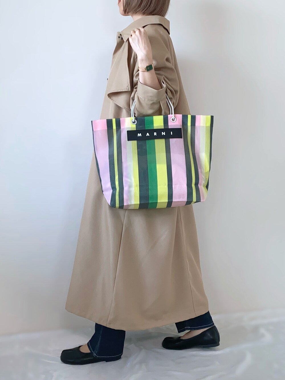 ベージュ系のトレンチコート、ピンク系のTシャツ/カットソー、グリーン系のトートバッグを着用したレディースの春コーディネートの2枚目の写真