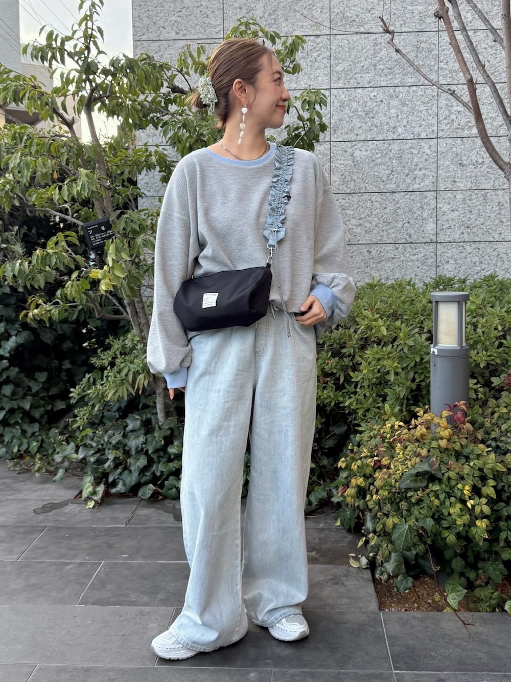 グレー系のTシャツ/カットソー、ブルー系のデニムパンツ、ホワイト系のスニーカーを着用したレディースの春コーディネートの2枚目の写真