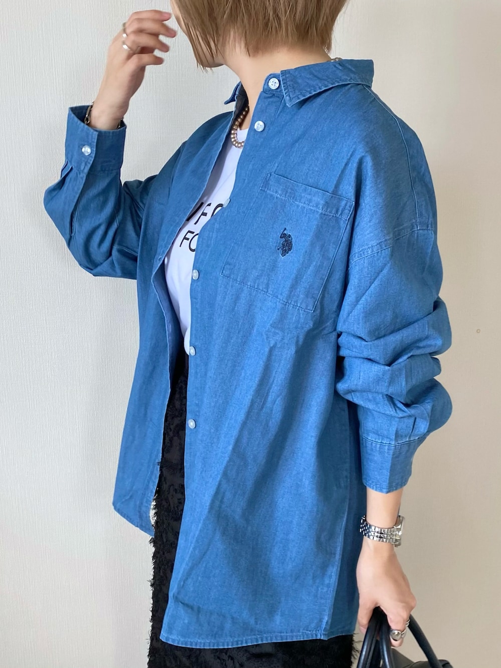 ブラック系のバッグ、ブラック系のスカート、ホワイト系のシューズを着用したレディースの夏コーディネートの5枚目の写真