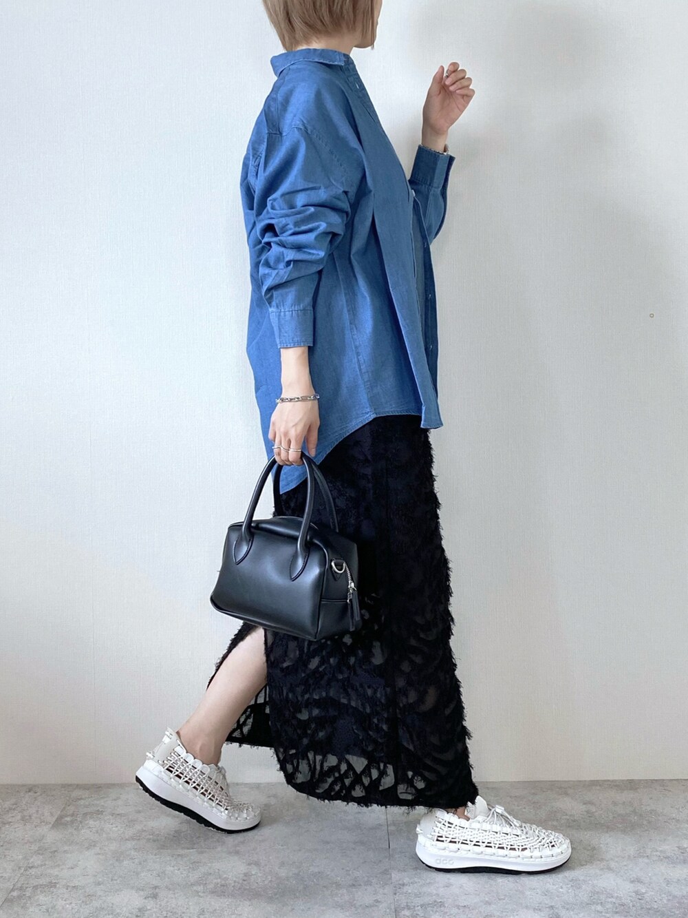 ブラック系のバッグ、ブラック系のスカート、ホワイト系のシューズを着用したレディースの夏コーディネートの3枚目の写真