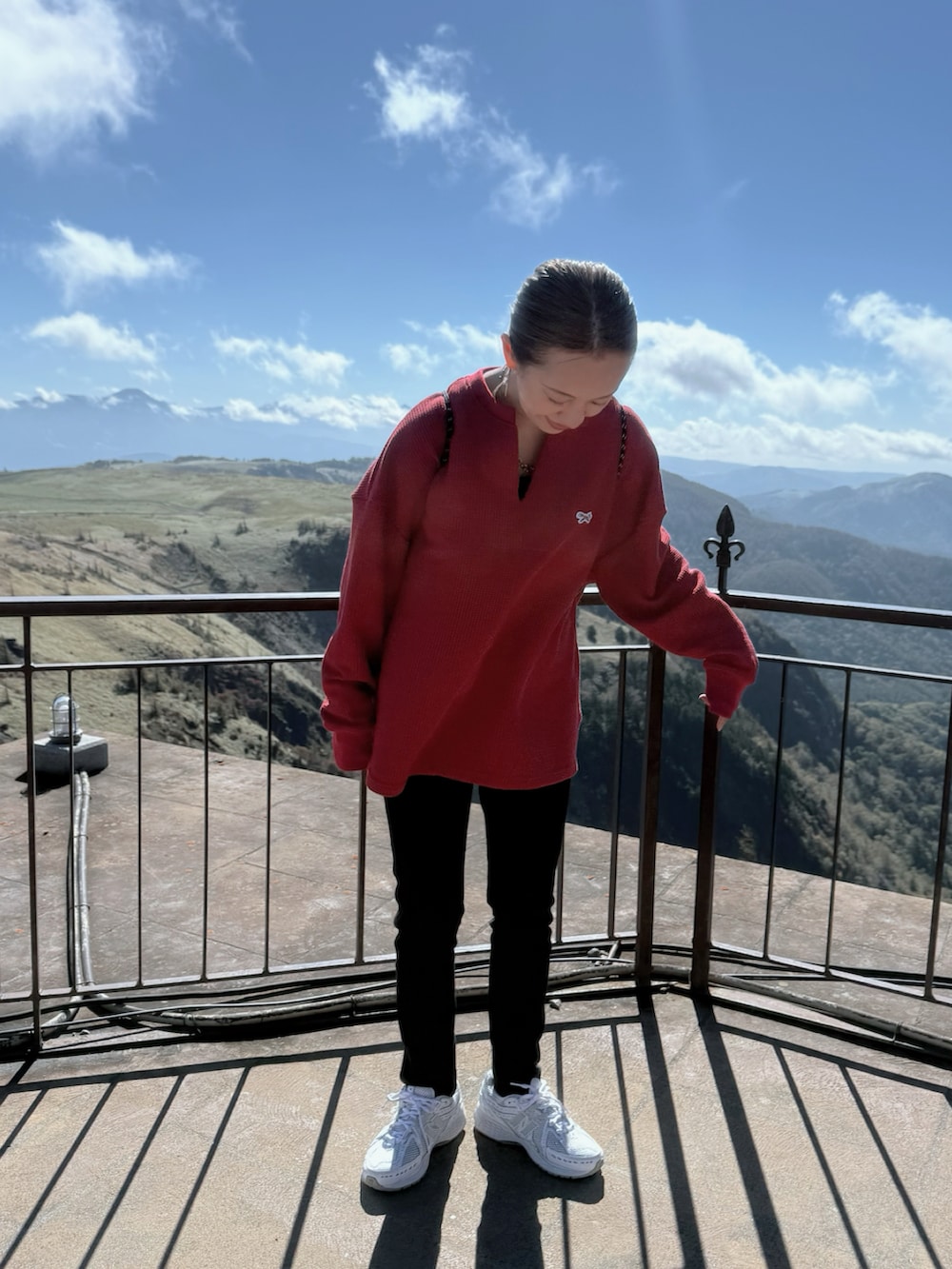 ホワイト系のスニーカー、レッド系のTシャツ/カットソー、ブラック系のバックパック/リュックを着用したレディースの秋コーディネートの5枚目の写真