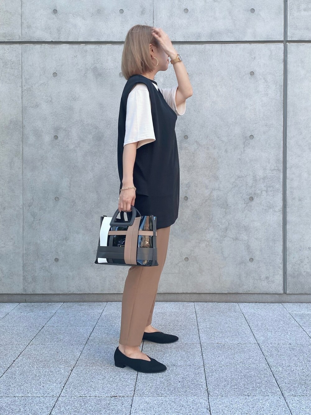 ブラック系のパンプス、ブラック系のバッグ、ブラウン系のその他パンツを着用したレディースの秋コーディネートの2枚目の写真