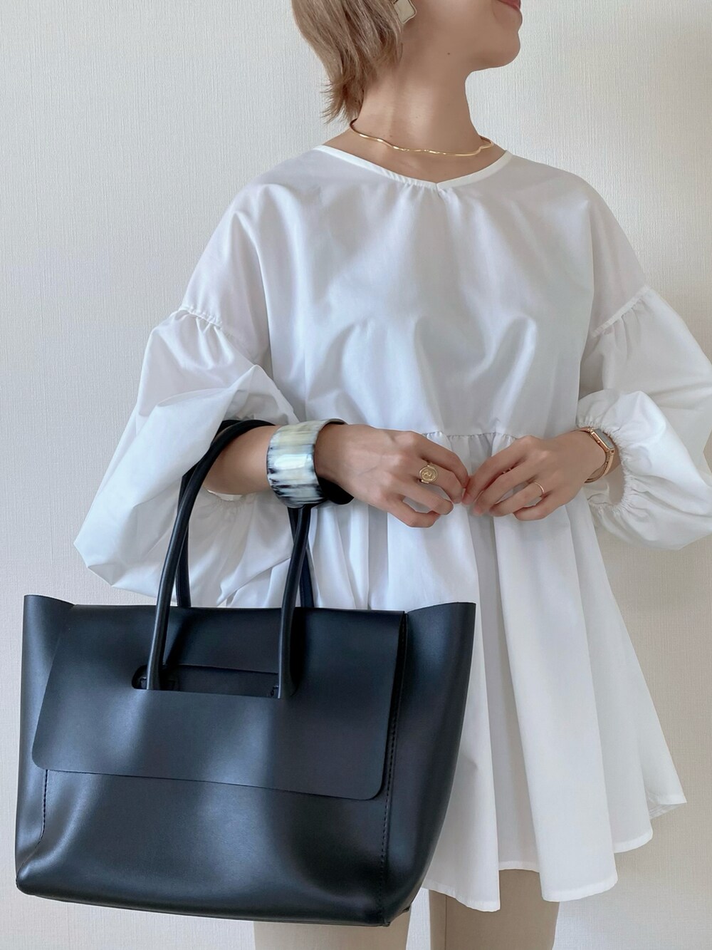 ブラック系のボストンバッグ、ホワイト系のシャツ/ブラウス、ブラウン系のローファーを着用したレディースの秋コーディネートの4枚目の写真