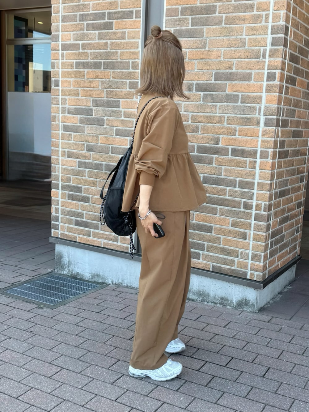 ホワイト系のスニーカー、イエロー系のその他パンツ、ブラック系のバックパック/リュックを着用したレディースの秋コーディネートの3枚目の写真