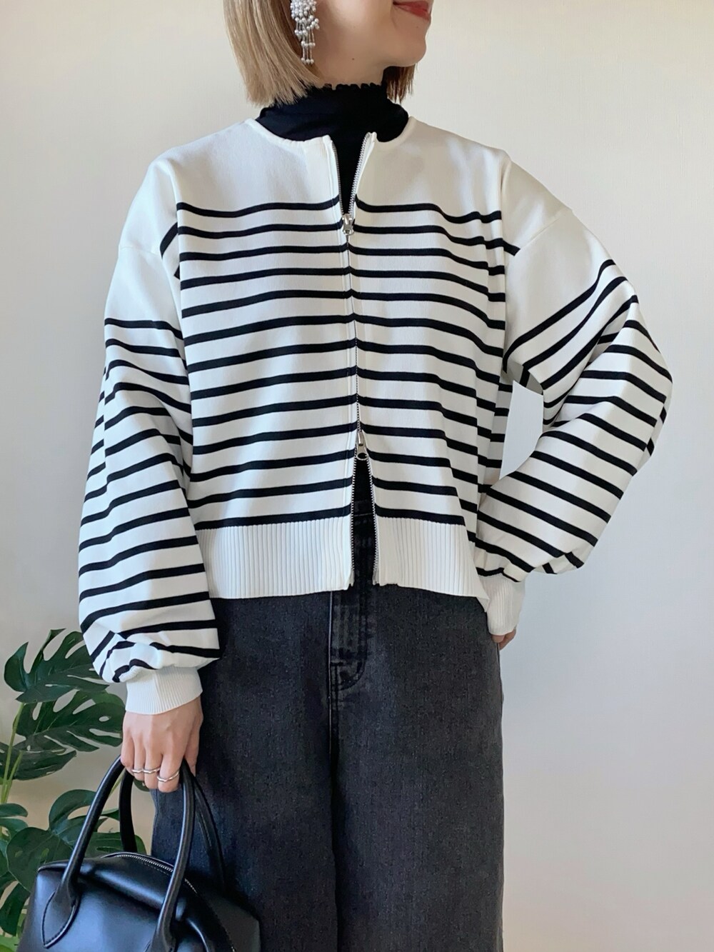 ホワイト系のカーディガン/ボレロ、ブラック系のデニムパンツ、ブラック系のバッグを着用したレディースの冬コーディネートの3枚目の写真