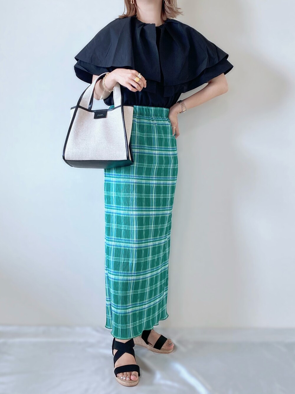 ブラック系のシャツ/ブラウス、グリーン系のスカート、ブラック系のバッグを着用したレディースの夏コーディネートの2枚目の写真