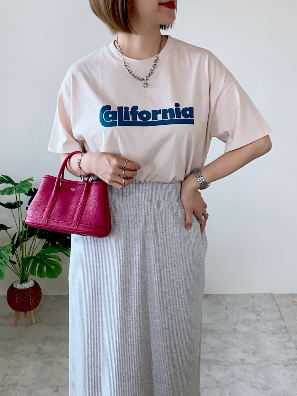 ベージュ系のTシャツ/カットソー、グレー系のスカート、グリーン系のサンダルを着用したレディースの夏コーディネートの2枚目の写真