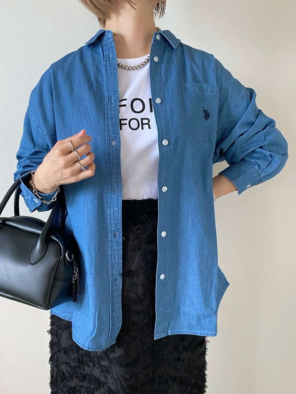 ブラック系のバッグ、ブラック系のスカート、ホワイト系のシューズを着用したレディースの夏コーディネートの4枚目の写真