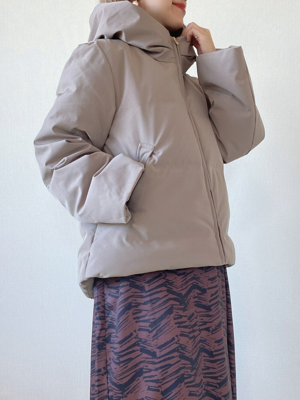 ブラウン系のダウンジャケット/コート、ブラウン系のワンピース、ベージュ系のブーツを着用したレディースの冬コーディネートの3枚目の写真