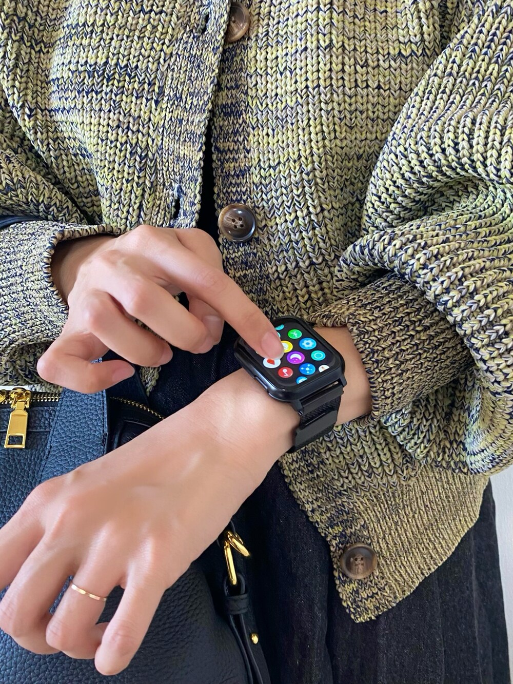 ブラック系のスカート、ブラック系のバッグ、ブラック系のブーツを着用したレディースの秋コーディネートの3枚目の写真