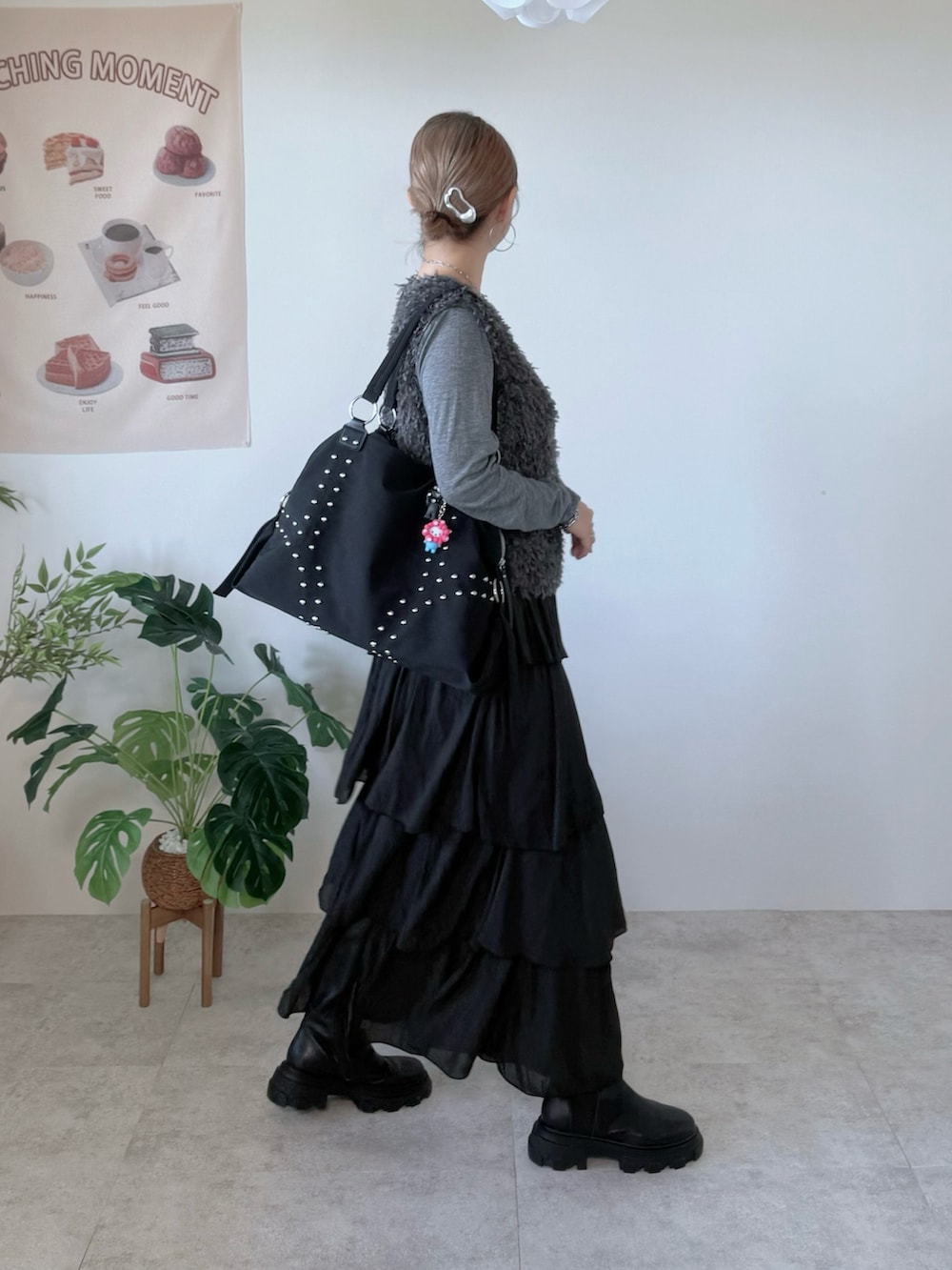 ブラック系のスカート、ブラック系のボストンバッグ、シルバー系のヘアピンを着用したレディースの秋コーディネートの2枚目の写真