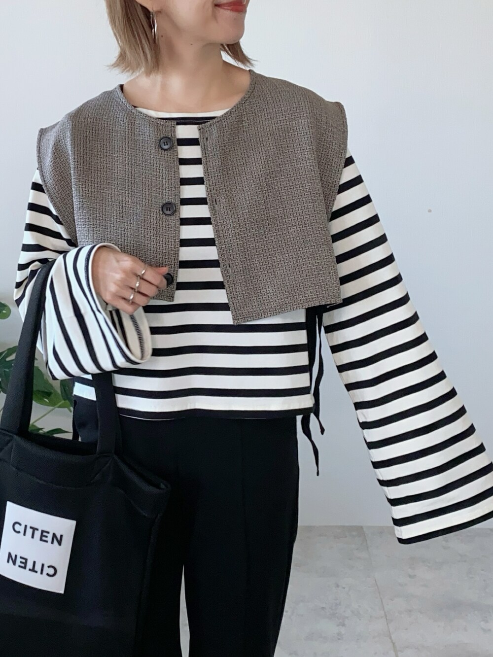 ブラック系のTシャツ/カットソー、ブラック系のベスト、ブラック系のトートバッグを着用したレディースの夏コーディネートの3枚目の写真