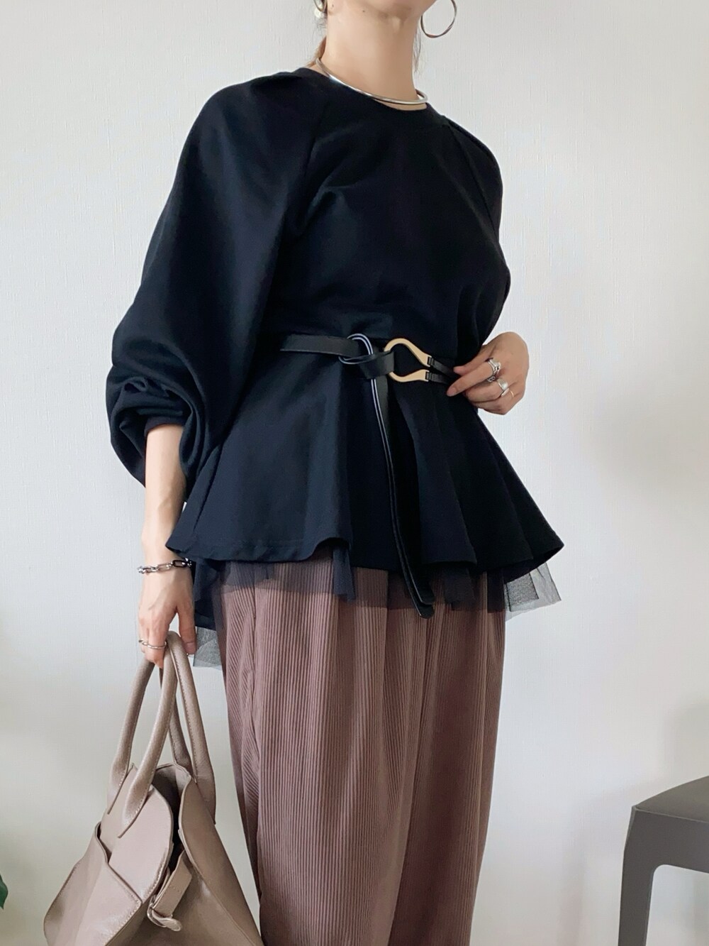 ブラック系のスウェット、ベージュ系のボストンバッグ、ブラック系のベルトを着用したレディースの秋コーディネートの4枚目の写真