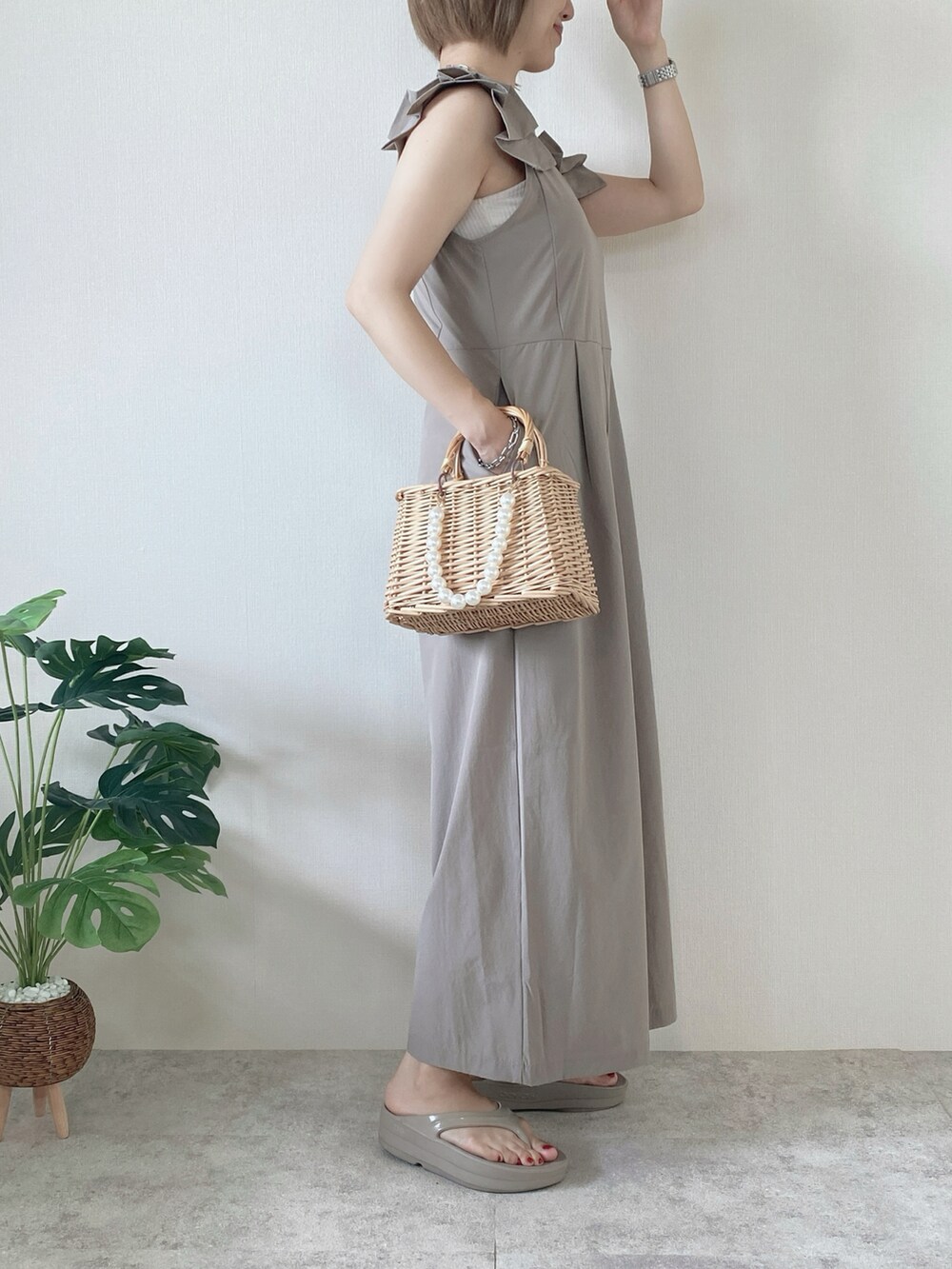 ベージュ系のかごバッグ、ベージュ系のサンダル、ベージュ系のラッシュガードを着用したレディースの夏コーディネートの2枚目の写真