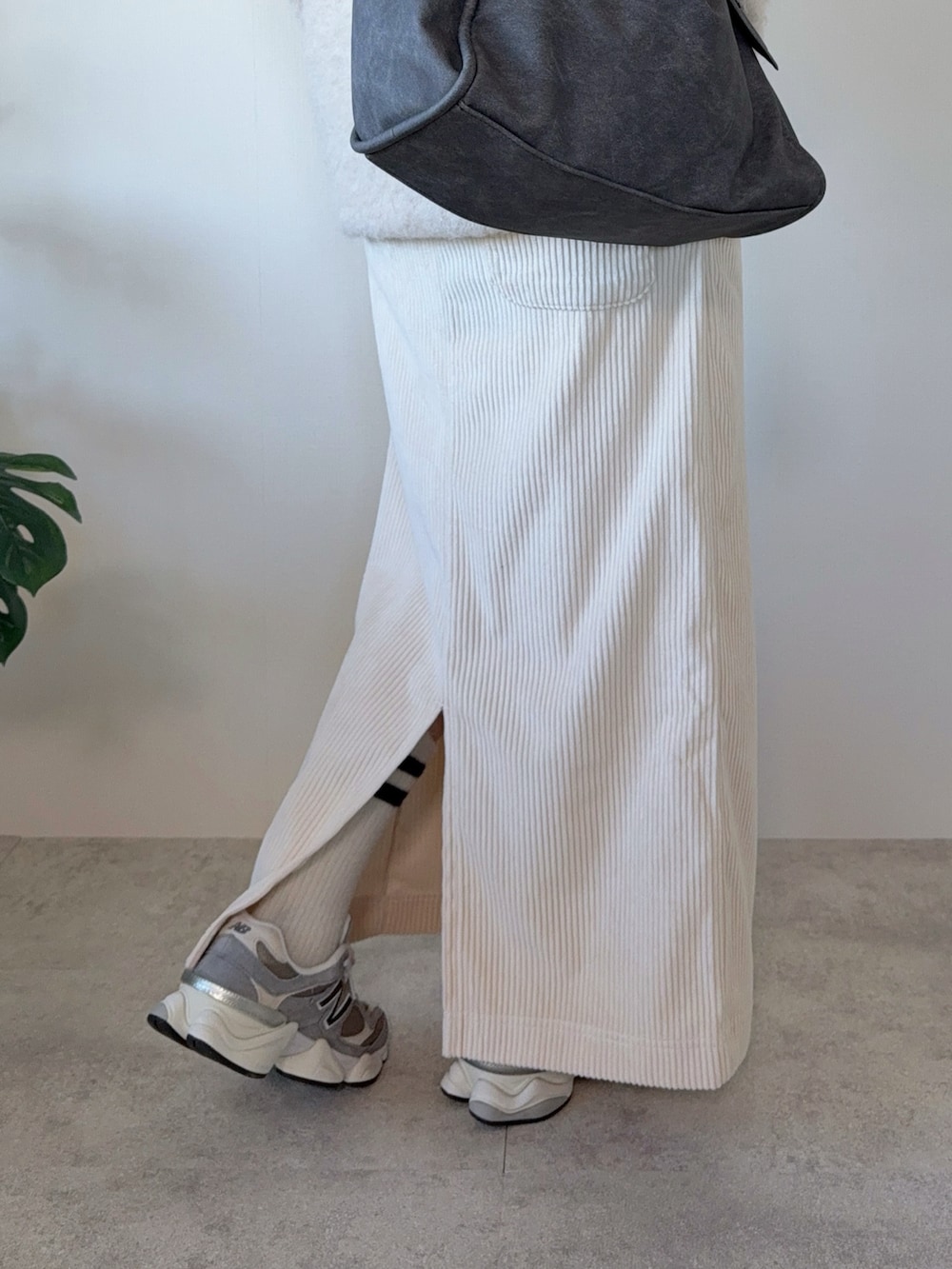 ベージュ系のニット/セーター、ベージュ系のスカート、グレー系のトートバッグを着用したレディースの冬コーディネートの5枚目の写真