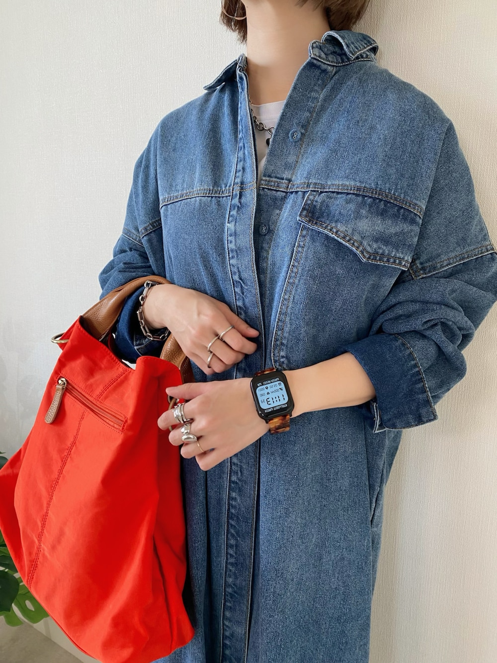 ブルー系のシャツワンピース、オレンジ系のトートバッグ、シルバー系のバレエシューズを着用したレディースの冬コーディネートの5枚目の写真