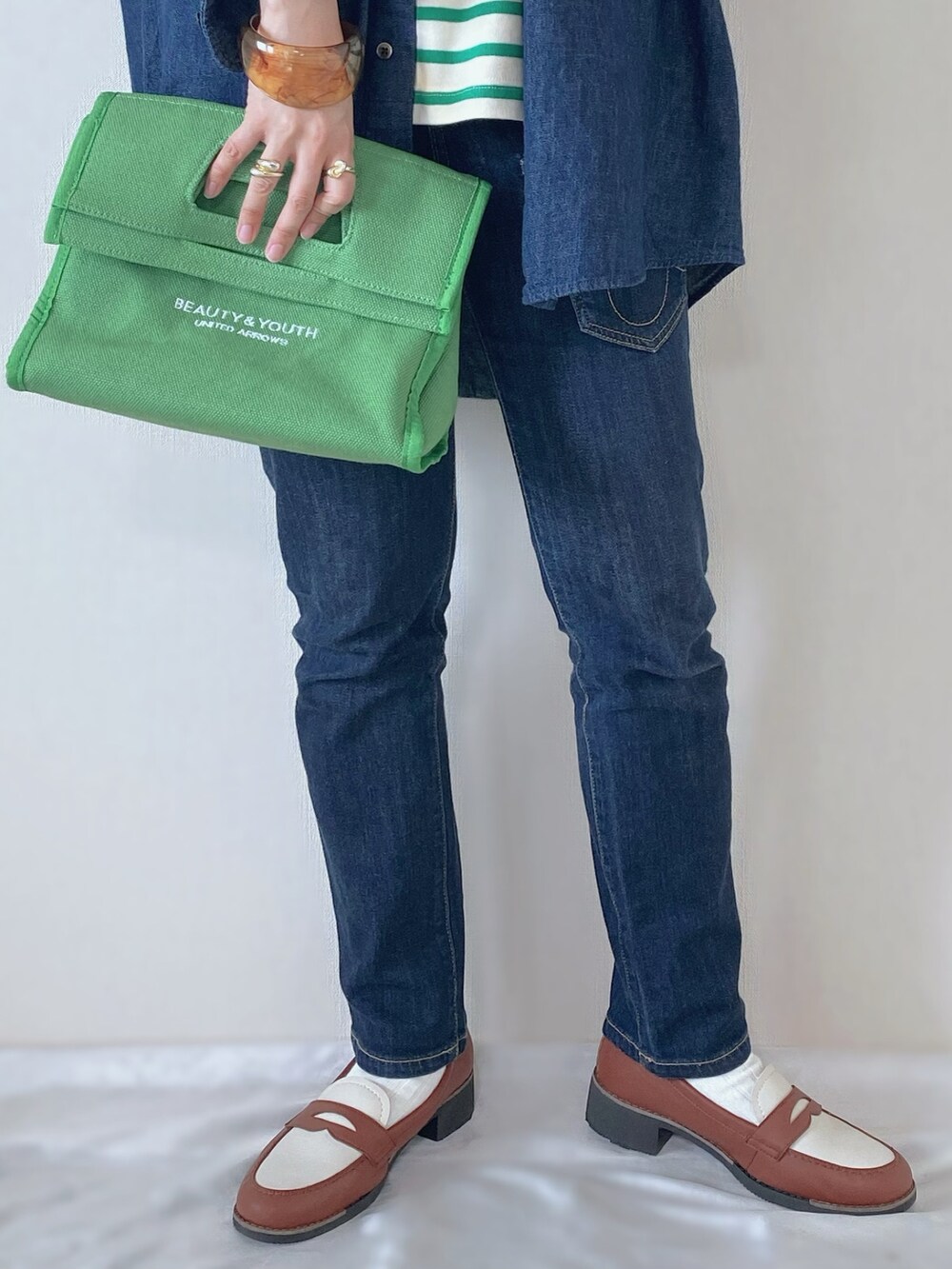 ブルー系のシャツ/ブラウス、グリーン系のTシャツ/カットソー、グリーン系のトートバッグを着用したレディースの春コーディネートの3枚目の写真