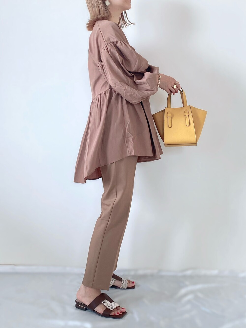 イエロー系のトートバッグ、ブラウン系のその他パンツ、ブラウン系のシャツ/ブラウスを着用したレディースの秋コーディネートの2枚目の写真