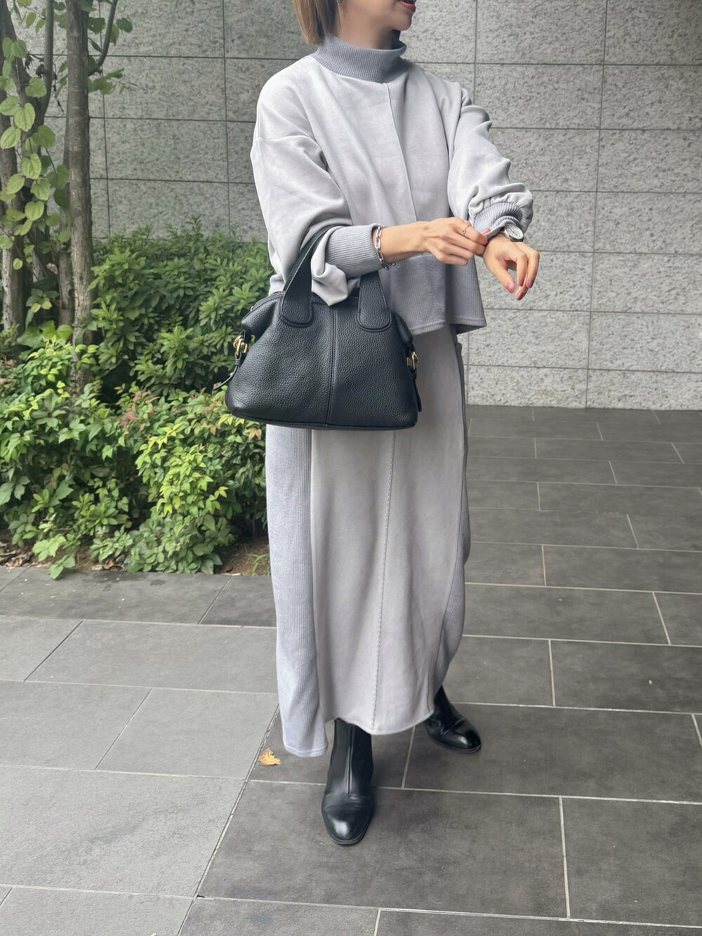 ブラック系のブーツ、ブラック系のバッグを着用したレディースの秋コーディネートの2枚目の写真