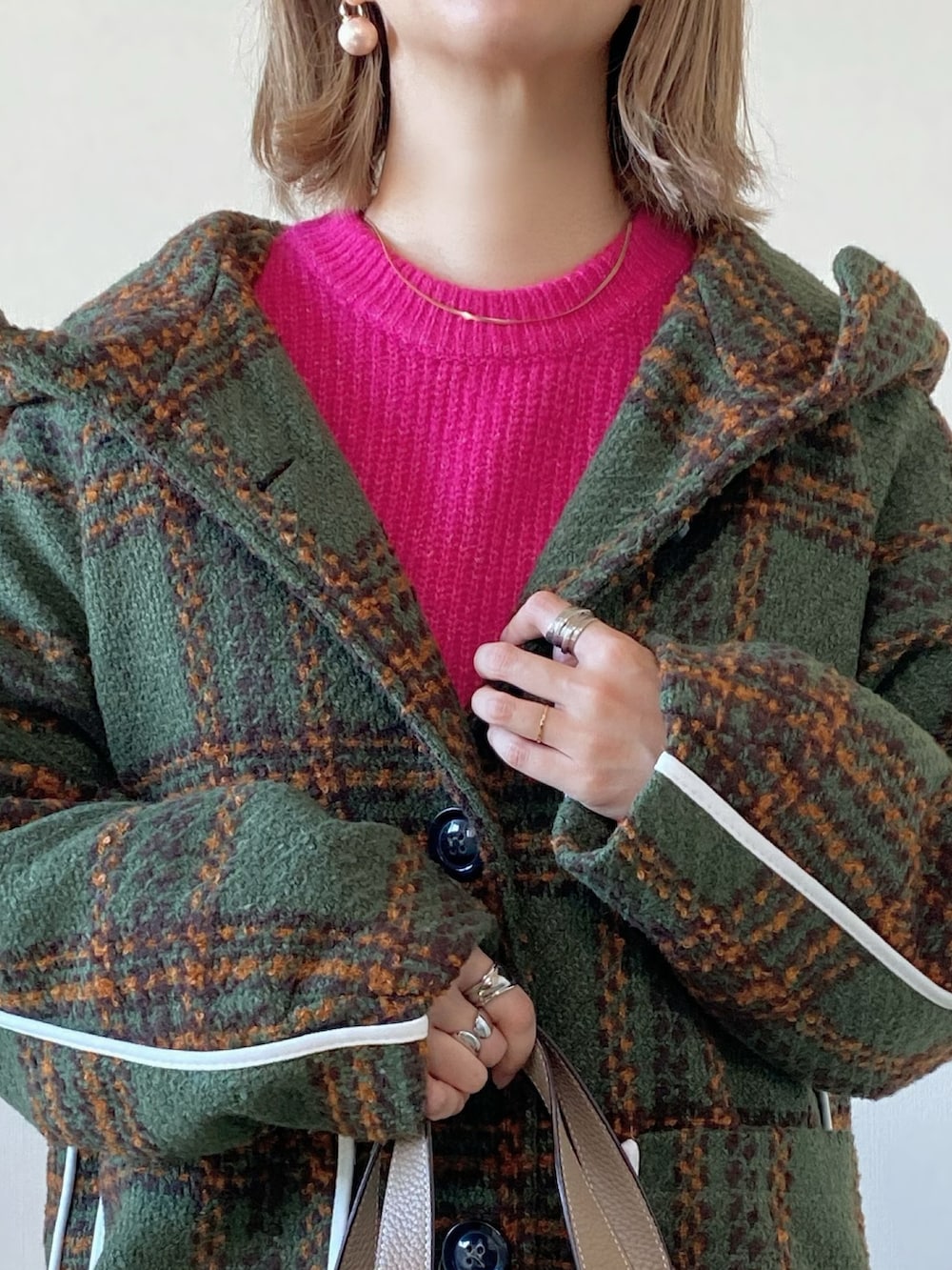 グリーン系のジャケット/アウター、ピンク系のニット/セーター、ベージュ系のバッグを着用したレディースの冬コーディネートの3枚目の写真
