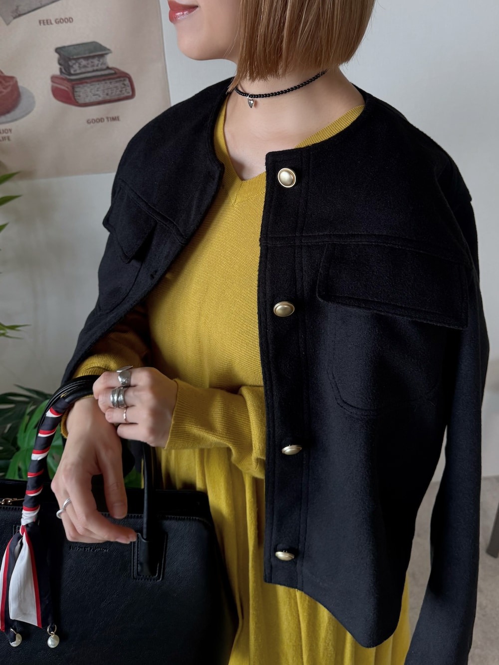 ブラック系のジャケット/アウター、ブラック系のハンドバッグ、イエロー系のワンピースを着用したレディースの冬コーディネートの4枚目の写真