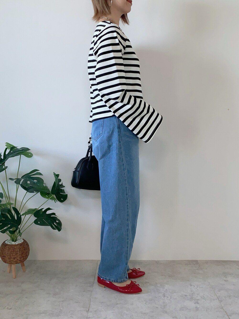 ブラック系のボストンバッグ、レッド系のバレエシューズ、ブラック系のTシャツ/カットソーを着用したレディースの夏コーディネートの4枚目の写真