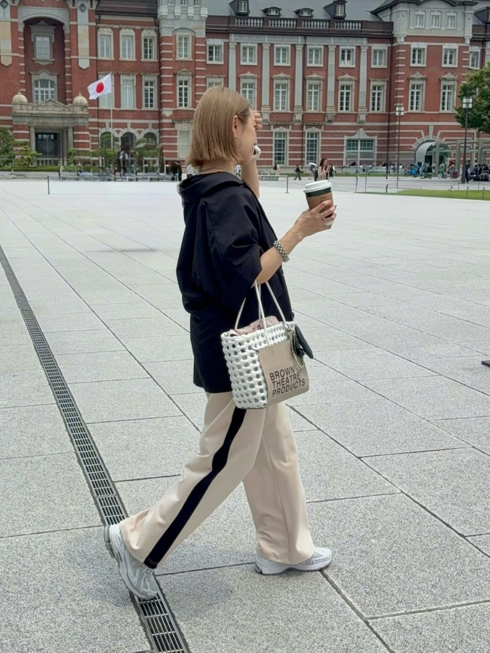 ホワイト系のスニーカー、ホワイト系のかごバッグ、ブラック系のジャケット/アウターを着用したレディースの夏コーディネートの3枚目の写真