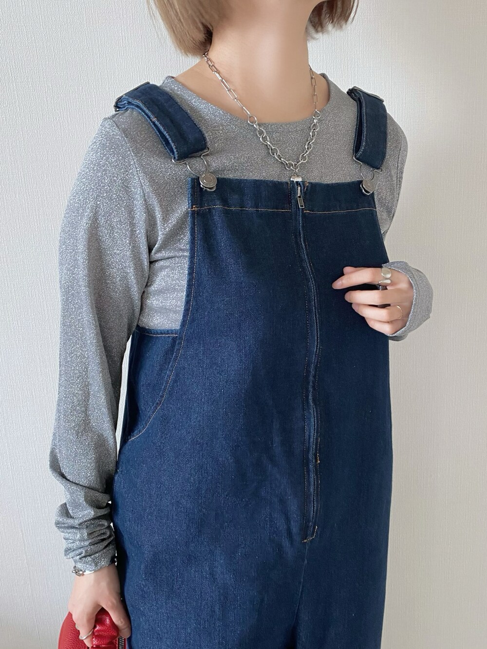 レッド系のボストンバッグ、グレー系のTシャツ/カットソー、ブルー系のサロペット/オーバーオールを着用したレディースの春コーディネートの5枚目の写真